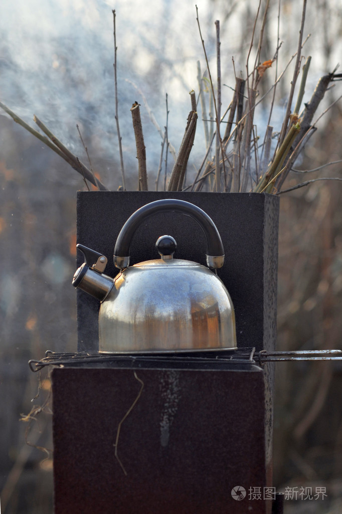 呼啸的水壶开始在火盆上沸腾