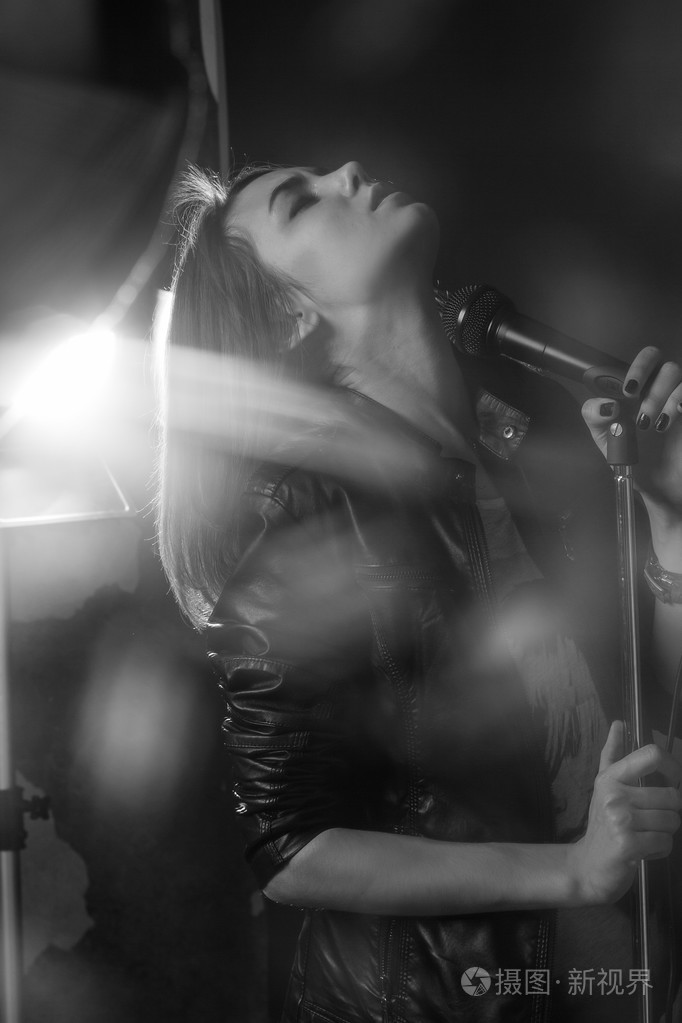 在演播室麦克风上歌唱的女孩