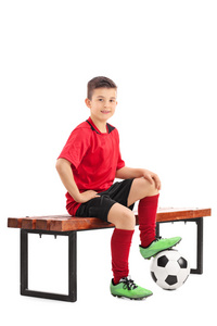少年足球运动员坐在长椅上