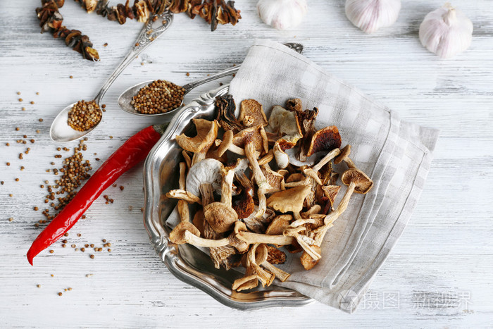 干蘑菇在板上木桌前,顶视图的香料