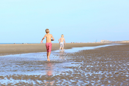 两个活跃的男孩在沙滩上玩