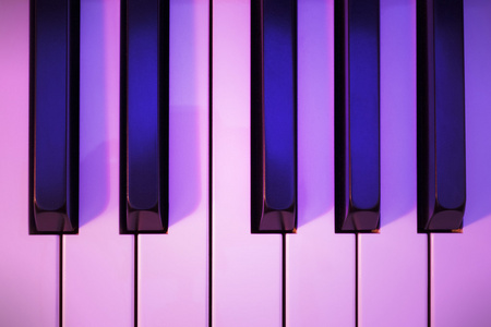 在彩色灯光下的钢琴键图片