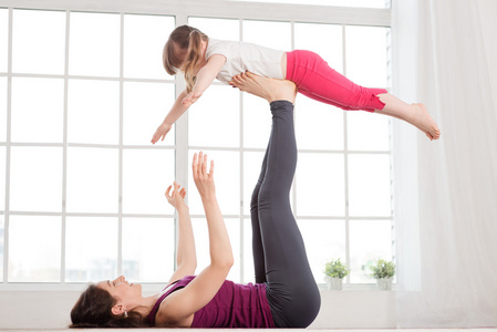 年轻的母亲和女儿做瑜伽运动