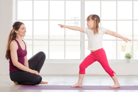 年轻的母亲和女儿做瑜伽运动