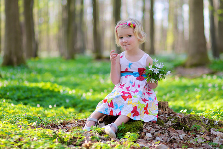 可爱的小女孩享受春天盛开的森林