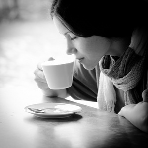 美丽的年轻女子，与一杯茶在一家咖啡馆