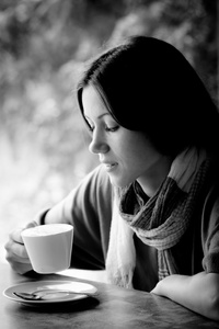 美丽的年轻女子，与一杯茶在一家咖啡馆
