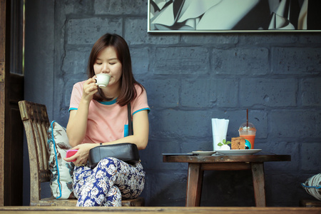 亚洲女孩享受茶亚洲妇女免费一天,在咖啡店里喝咖啡放松时间在咖啡店