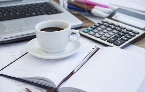 在办公室与财务文件 议程和计算器的咖啡杯