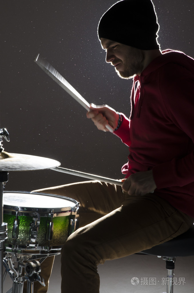 年轻的鼓手打在中心的灯光