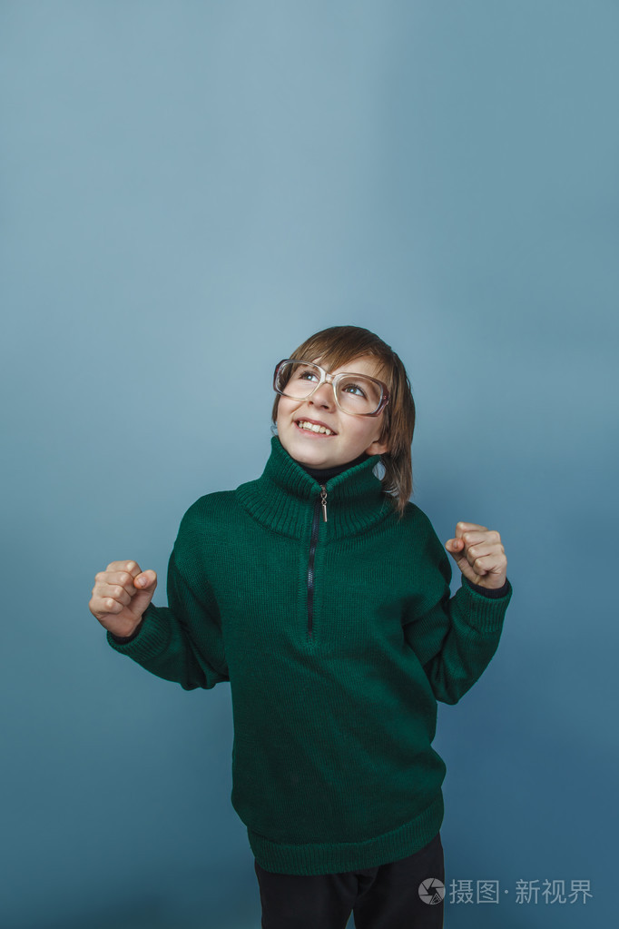 欧洲人的小男孩在眼镜上灰色背景的十年