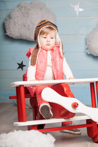 小女孩坐在木制玩具飞机