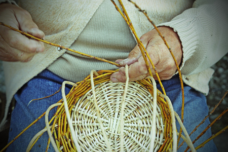 老工匠创建编织的柳条篮子