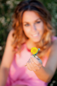 女人拿一朵黄色的花