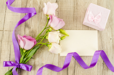 空的明信片 花和紫色的丝带上木制背景