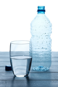 空瓶子和水在一张木桌上的玻璃