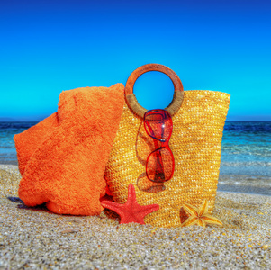 稻草袋 沙滩巾和太阳镜在沙滩上