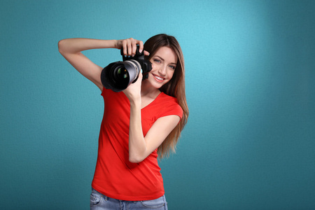 年轻的女摄影师，拍摄照片蓝色背景