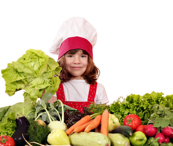 小女孩厨师与绿色沙拉和蔬菜