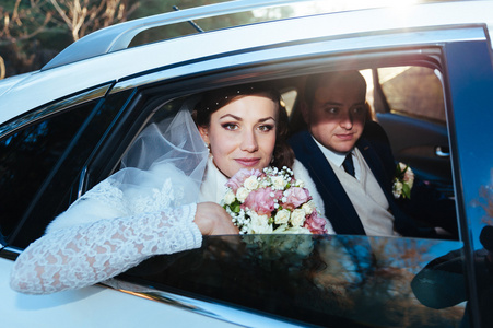 幸福的新娘和新郎在车里的肖像