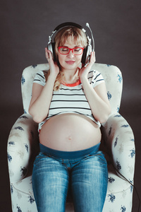 孕妇在耳机上听音乐