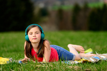 漂亮的年轻姑娘在自然听音乐