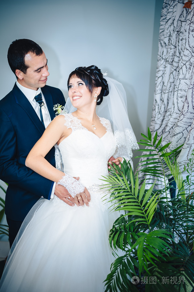 迷人的新娘,新郎用拥抱和亲吻他们的婚礼庆典在豪华的餐厅.