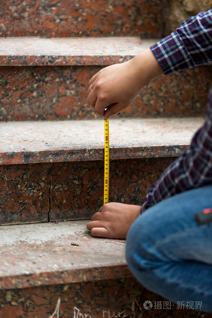 工人的石头台阶高度测量的特写