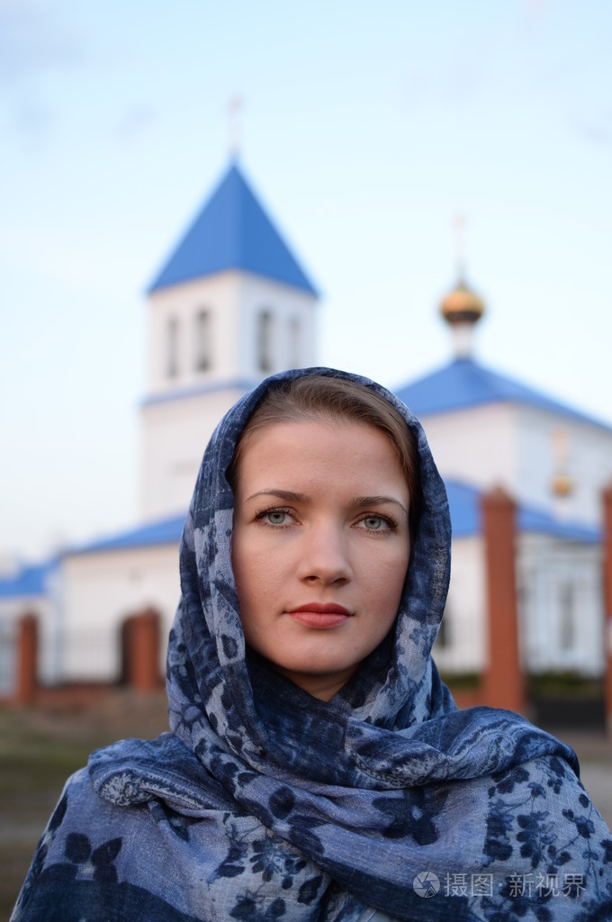 一个女孩斯拉夫俄罗斯出现在教会的背景上的一条围巾