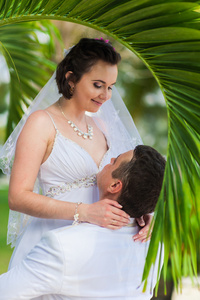 爱的年轻夫妇在热带海面背景在海滩上的婚礼