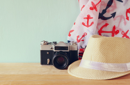 头戴呢帽 围巾和旧的老式相机，在木制的桌子上。放松或度假的概念