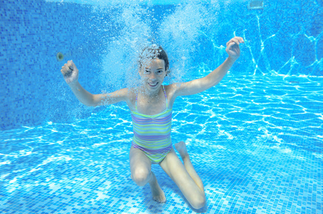 快乐的女孩在游泳池水下，活跃孩子游泳游泳