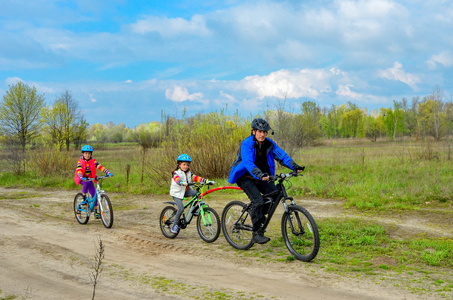 幸福的家庭，骑自行车，父亲和孩子们在户外骑自行车
