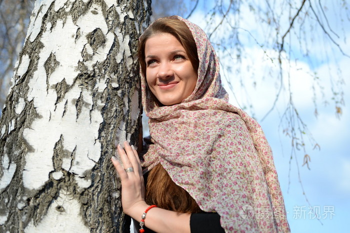 俄罗斯姑娘在一条围巾在白桦林关闭