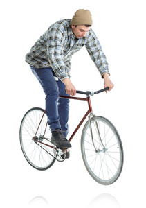 年轻人在一辆自行车在一张白纸上的把戏