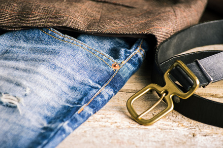 蓝色的皮革皮带解开的皮带上一褪了色的蓝色牛仔裤的细节照片