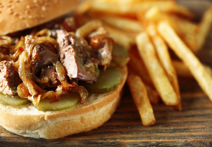 美味的汉堡和薯条在木桌背景下，特写不健康食品的概念