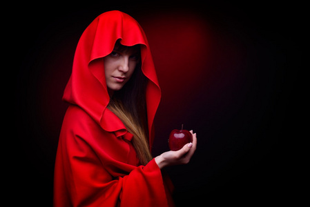 美丽的女人，拿着苹果工作室拍摄的红色斗篷