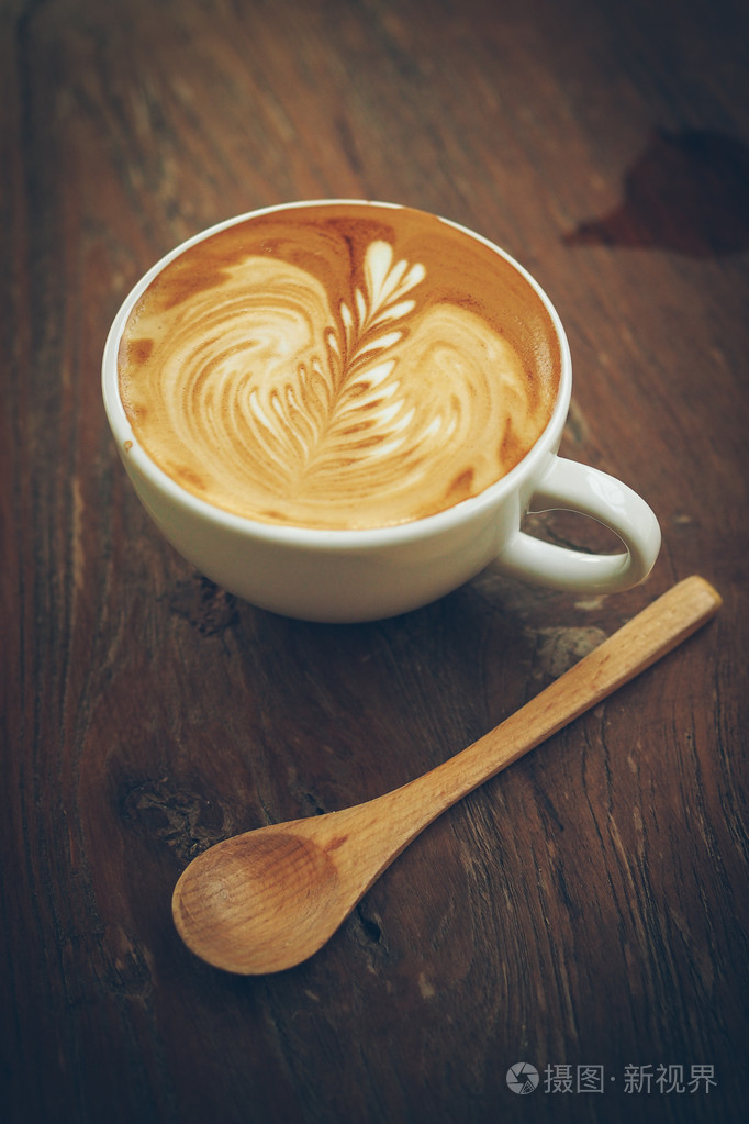 cup的木桌上的咖啡拿铁艺术