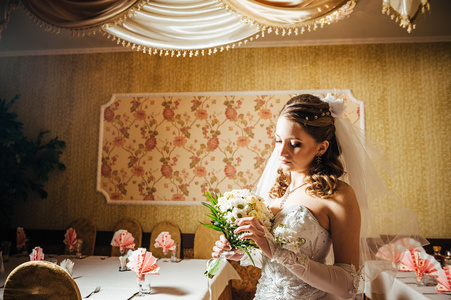 画像上豪华的内饰，在婚礼当天的花束的美丽新娘