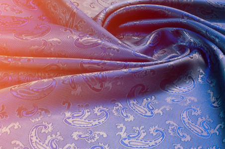 丝绸织物的质地。 深蓝色。 有黄瓜的照片。 蚕在制造蚕茧过程中产生的一种优良的柔软的有光泽的纤维，并收集起来制成线和织物