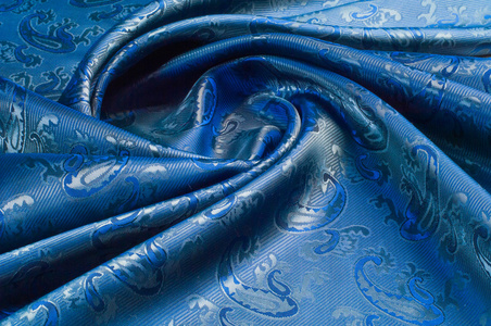 丝绸织物的质地。 深蓝色。 有黄瓜的照片。 蚕在制造蚕茧过程中产生的一种优良的柔软的有光泽的纤维，并收集起来制成线和织物