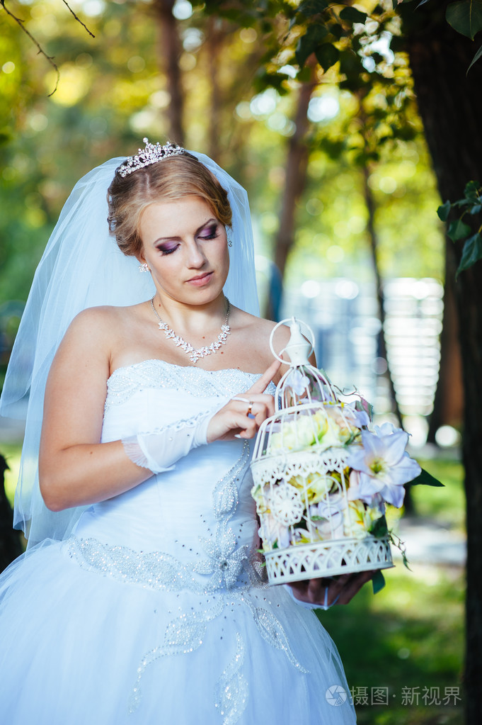 美丽的新娘摆姿势在公园里,室外,在她的婚礼当天照片-正版商用图片1j