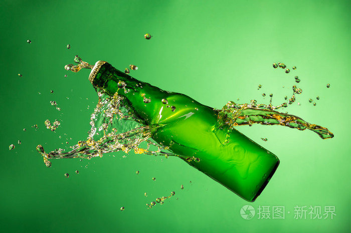 瓶啤酒时溅起水花绿色背景上
