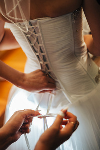 美丽的新娘准备在白色的婚纱礼服发型与亮妆。快乐的女孩等待新郎。在婚纱的浪漫女士有为婚礼做最后准备
