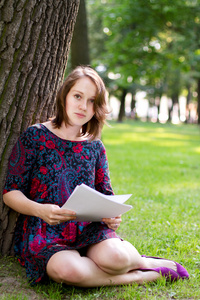 年轻女子坐在一棵树下
