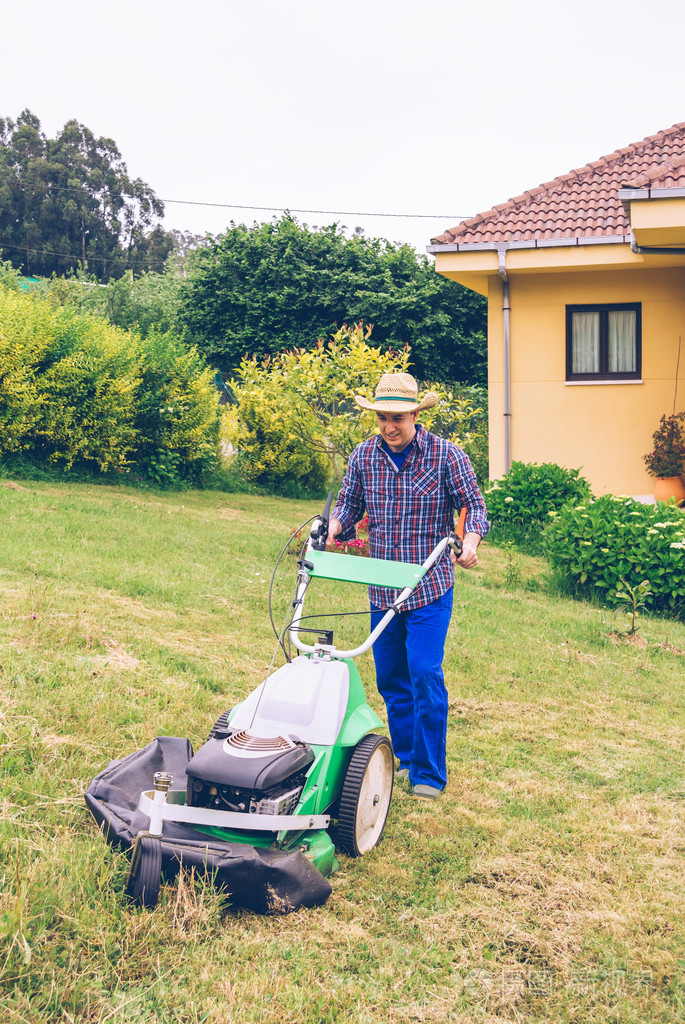 年轻人用割草机草坪割草