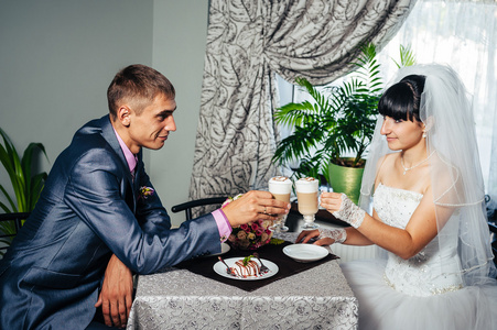 迷人的新娘和新郎在他们的婚礼庆典在豪华的餐厅。在日期上的恩爱夫妻