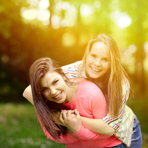 两个年轻女孩朋友在公园的一个拥抱