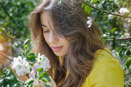 美丽年轻的黑发女人，朵朵春天的花园里